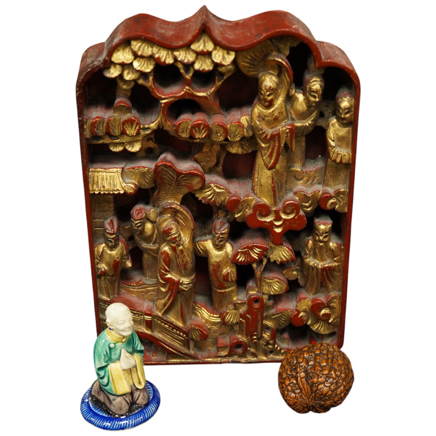 A Chinese carved and giltwood panel, sancai figure and carved coquilla nut, largest 21 x 14.5cm